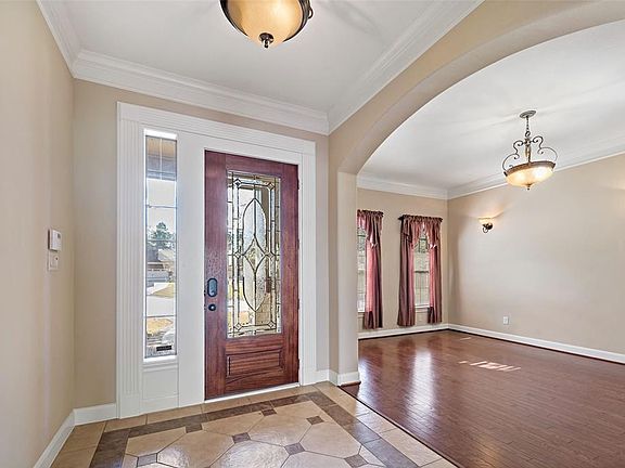 As you enter the house you find a beautiful tile design and on the left is the formal living/media room. Enhancing the architectural features is the archways and the crown molding throughout the home.