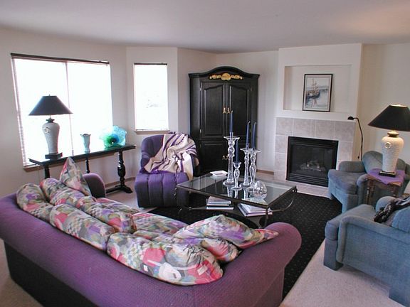 Formal living room with bay window, gas fireplace and space for oversize furniture. The carpet is new and neutral.