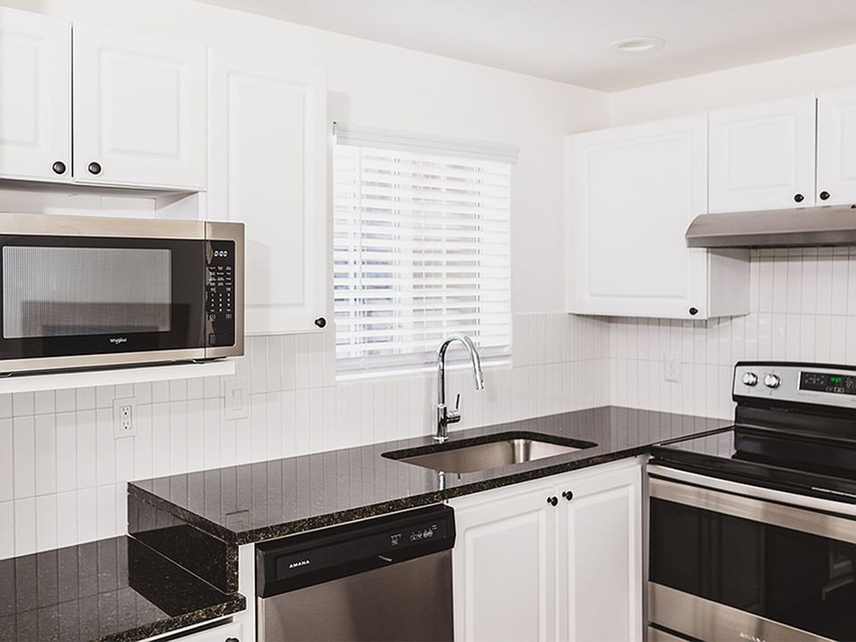 Gourmet kitchens with granite countertops, custom white cabinetry with chrome pulls