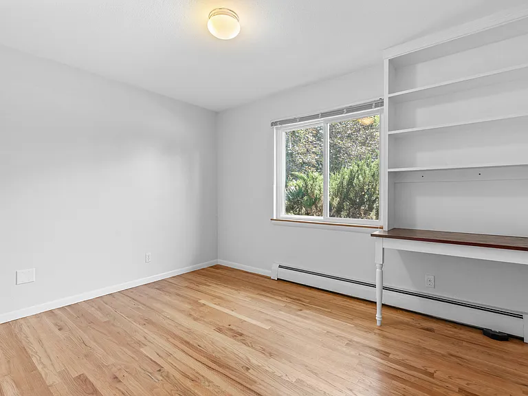 The custom built-in adds character and flexibility, making this space ideal as a bedroom, home office, or creative space.
