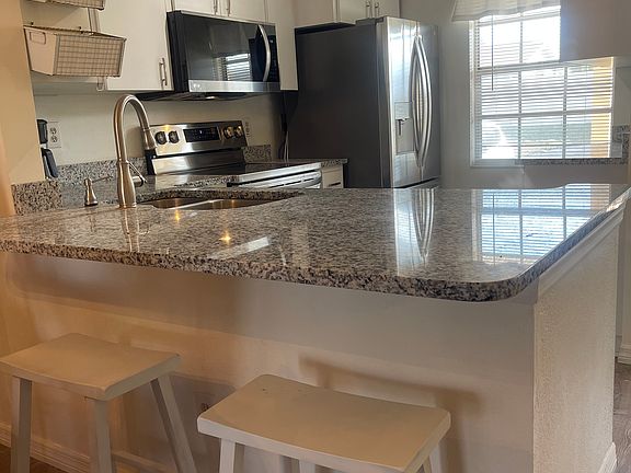 This is a breakfast bar open to the kitchen. The kitchen has new flooring, cabinets, sink, faucet, granite counter tops and new appliances.