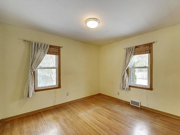 Large first bedroom on main level has 2 windows for plenty of light and continues with the original the hardwood floors