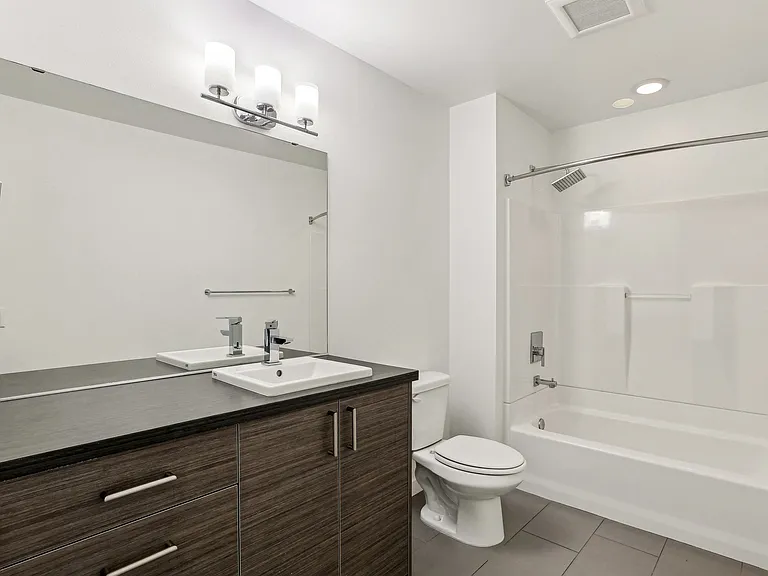 Contemporary bathroom at 4400 Alaska in Seattle, WA, featuring a sleek dark wood vanity, modern sink, and a convenient tub/shower combo. Perfect for urban li...