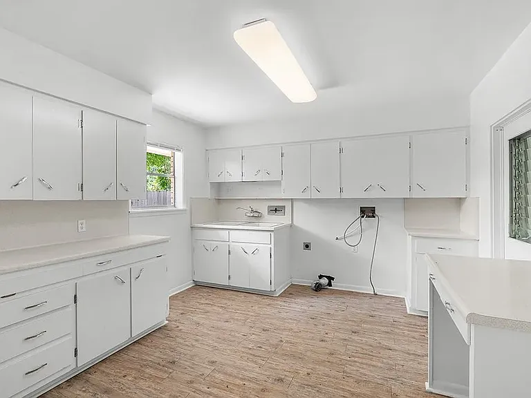 Spacious Utility/Hobby/Sewing Room with room for stools under counter for hobbies, sewing, etc. and lots of storage cabinets and hanging closet.
Door into garage for easy moving of laundry appliances into Utility Room. Window looking into back yard.