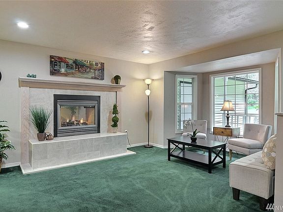 Living room with 2 sided gas fireplace and bay window area.