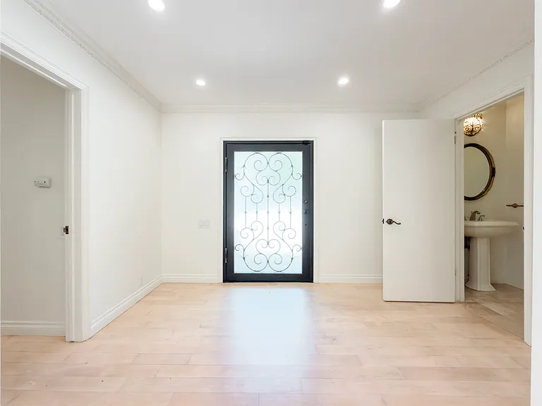 Grand entryway with a decorative wrought iron front door welcomes guests to this Beverly Hills luxury rental at 1094 Garden Lane, a premier 90210 home for rent.