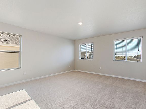 The master bedroom is spacious and has large windows.