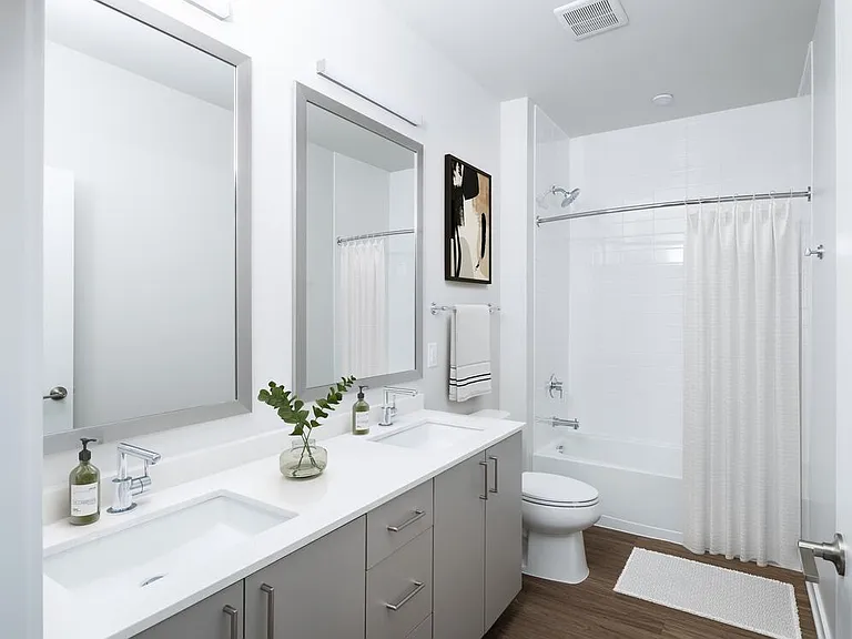 Design Collection II bath with cream quartz countertop, oak cabinetry, and hard surface flooring