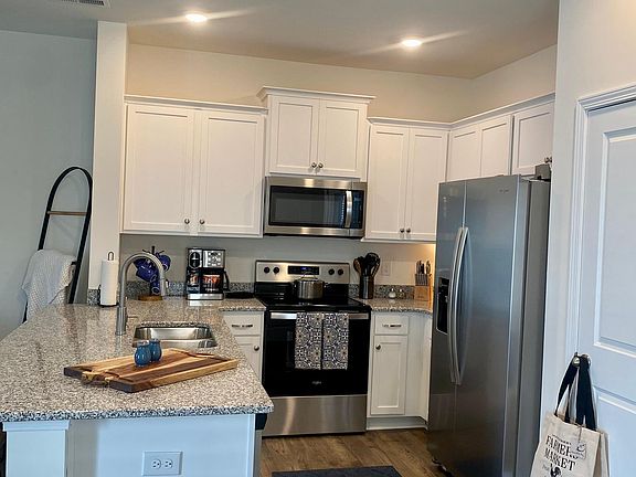 Kitchen with stainless steel appliances, Cuisinart 3 in 1 coffee center, and all table wear included.