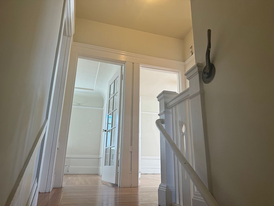 The foyer with the antique door lever on the wall. Kitchen to the left with the living room and one bedroom straight ahead