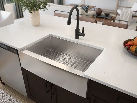 Stainless steel apron-front sink with matte black faucet