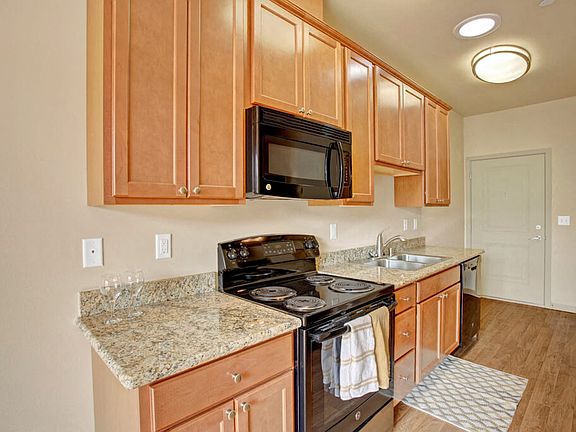 An open kitchen with a deep double sink, lots of cabinet storage, and plenty of counter space
