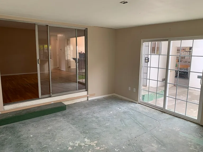 Enclosed back porch. Cement floor, sliding glass door, multiple windows.