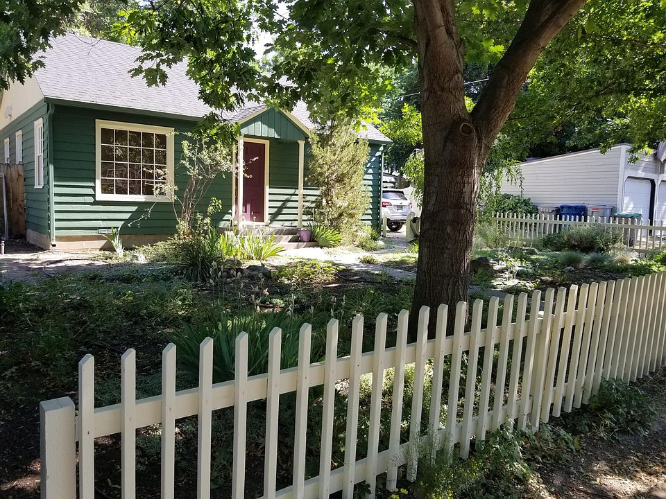Picket fence with two gates. Zero scape yard with maintenance service.