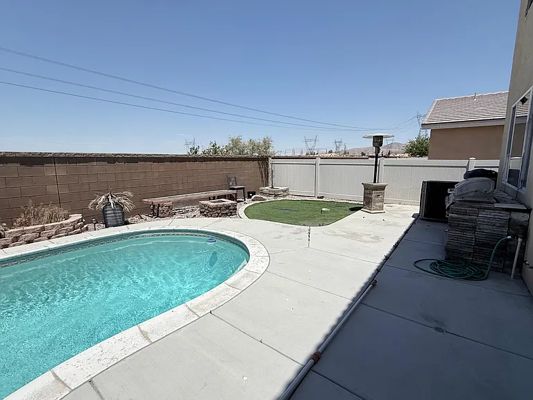 Private backyard patio with a pool, low-maintenance landscaping, and fenced outdoor space for relaxing or entertaining.