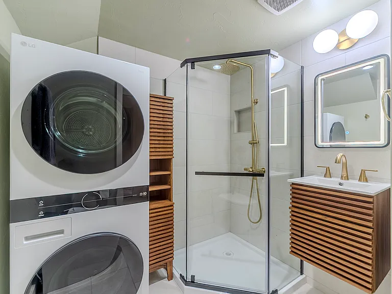 Brand new bathroom with LED mirror, storage cabinet, and washer/dryer
