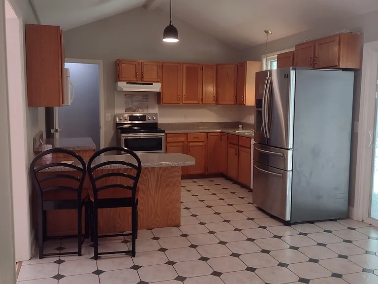 Kitchen with tile floor, stainless refrigerator and double oven range, DW and MW, breakfast bar with seating