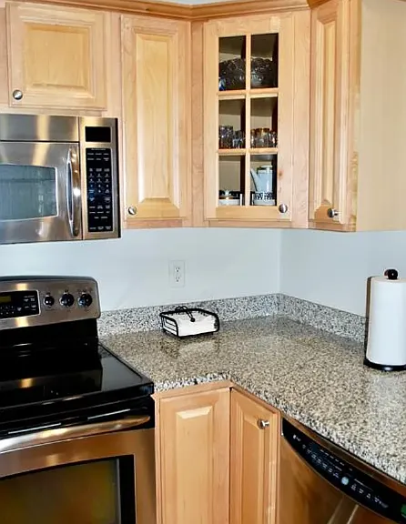 Modern kitchen with stainless steel appliances, including a new refrigerator. Granite counter tops.