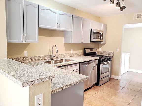 Granite counters, gray cabinets, new stainless steel appliances and double sink. Lovely pull out kitchen faucet. Modern track light.