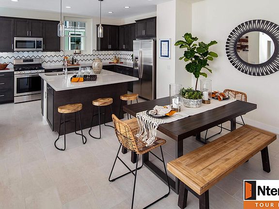 Stainless steel appliances, pendant lighting, tile flooring in kitchen
