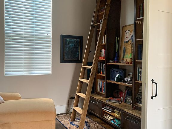 Through the front door, library on the left with 20 ft ceiling.