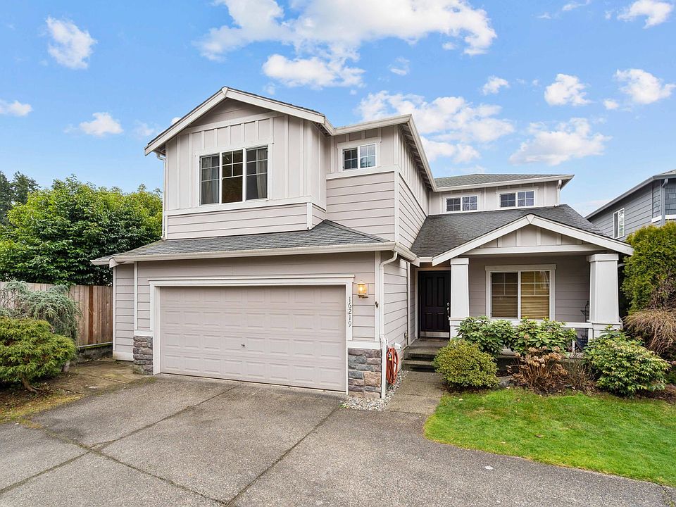 Front of house with porch. 2-car garage with long driveway.