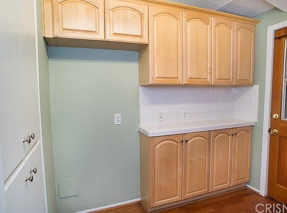 The additional kitchen cabinets and storage with direct access to the laundry room and two car attac