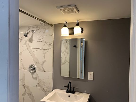 Bathroom with full-sized shower and vanity.