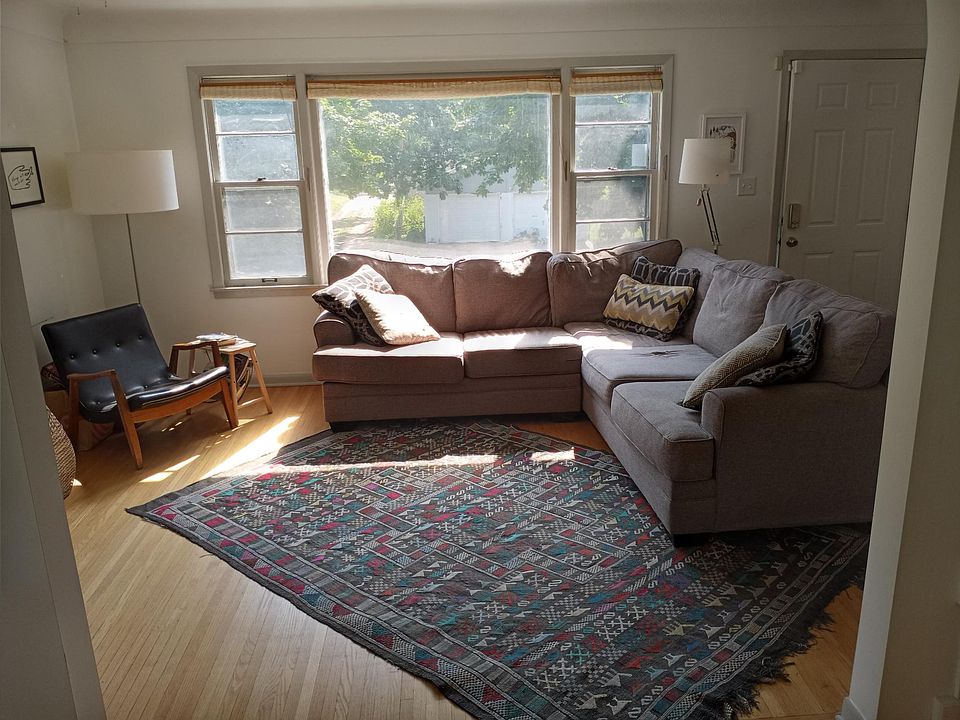 Main living room space with front door and large picture window