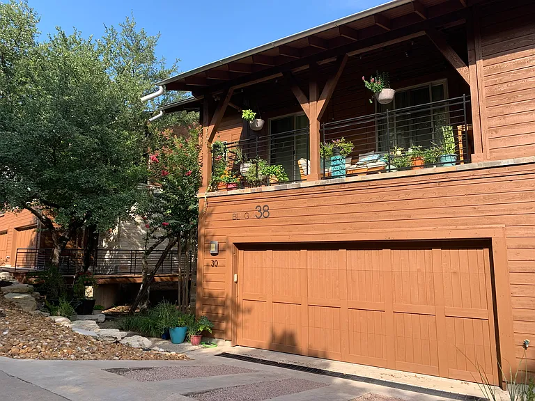 Front of Condo with view of Upstairs Patio and 2-car garage