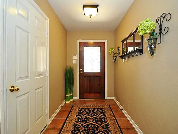 Tiled entry way has custom paint and a beautiful glass inlay solid wood door.