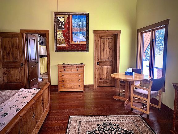 Master Bedroom with seating area, hard wood floors throughout home, beautiful art, private bathroom