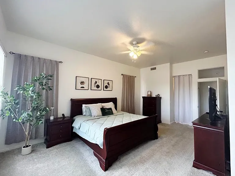 Large primary bedroom with king size bed, dressers, smart tv, reading nook.