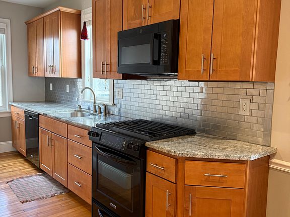 Kitchen features stainless steel backsplash and granite countertops