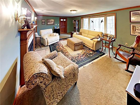 Welcoming living room with a beautiful bay window looking over the wooded lands below.