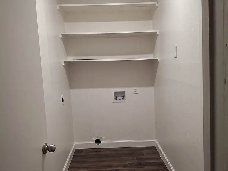Laundry space. WD connections. Fits stackable or set of compact WD units. To right is door to garage.