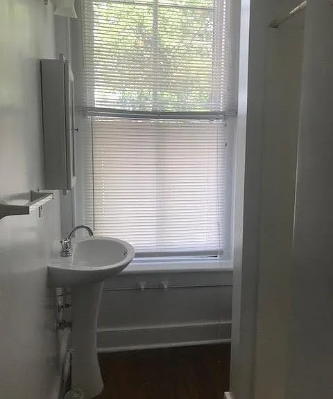 This bathroom, with washer and dryer has a shower stall.