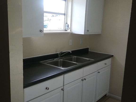 Kitchen has ample cabinets and a double sink.
