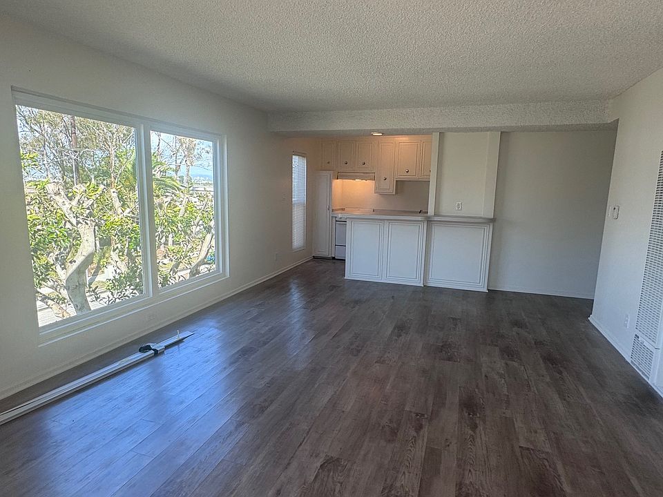 Spacious and bright living room and kitchen with beautiful new sliding glass door to balcony and windows throughout