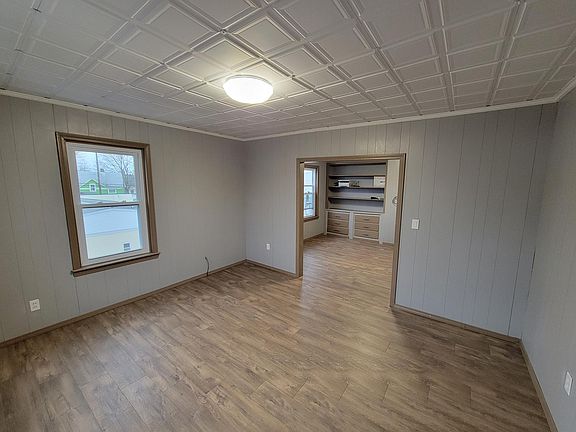 Living room and view of built in bookcase with drawers in dining room
