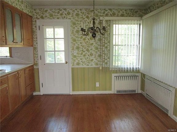 Dining room with hardwood floor and door to patio, deck and yard.