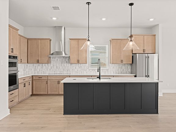 The kitchen has beautiful designer wood cabinetry.