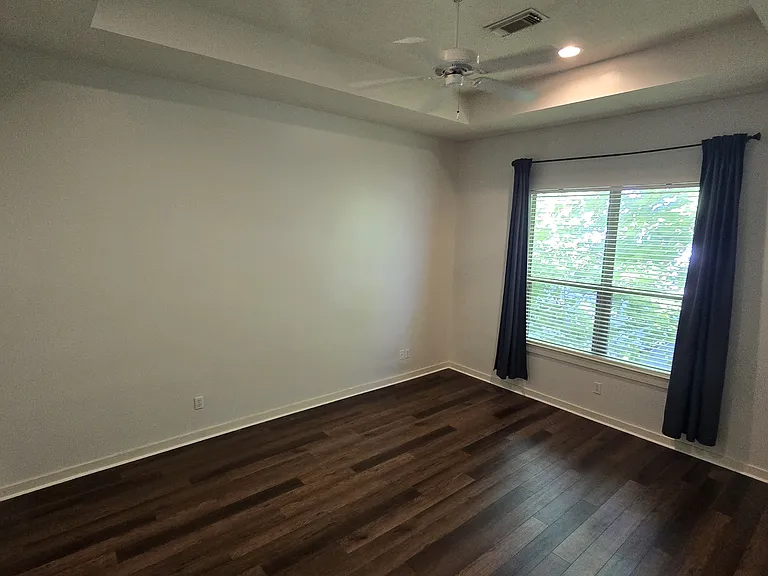 Master bedroom is spacious and has windows that open and allow natural light.