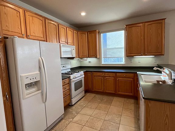 Warm open kitchen with all appliances, under-cabinet lighting and plenty of storage.