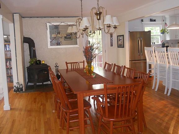 Dining Room with Wood Stove and Hardwood
        Floors