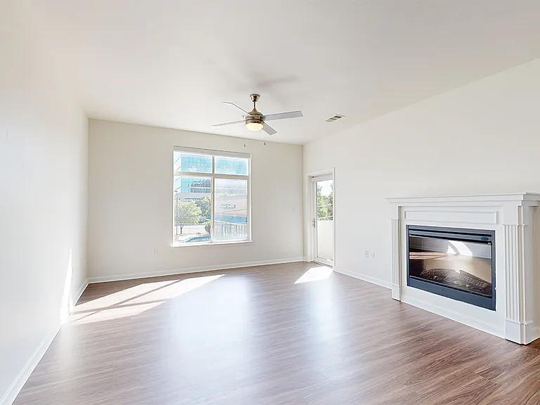 Apartment living room with wood-style flooring and fireplace.