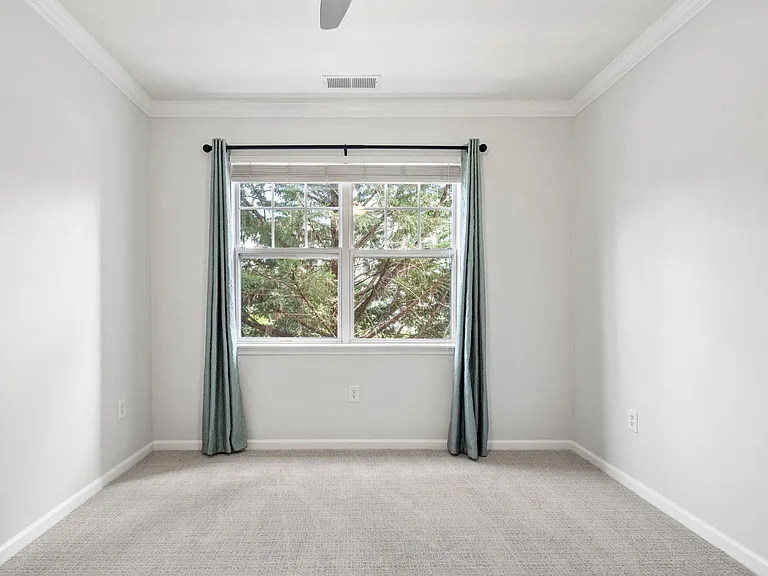 Guest bedroom with new curtain rod. Curtain is option. Arborvitae tree view. Remote ceiling fan.