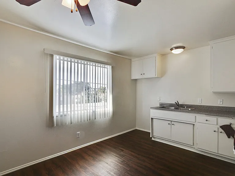 Dining area with ceiling fan, wood style floors, open kitchen on the right