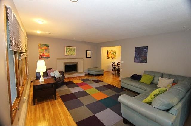 Lights of light with all the window in the living room with beautiful real oak hardwood floors and a wood burning fireplace.