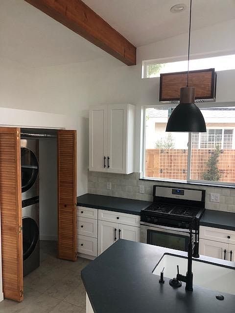 Stackable washer/dryer that disappears behind a beautiful wood closet.